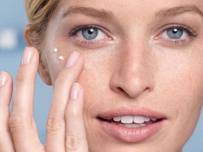 applying a cream to rejuvenate the skin around the eyes